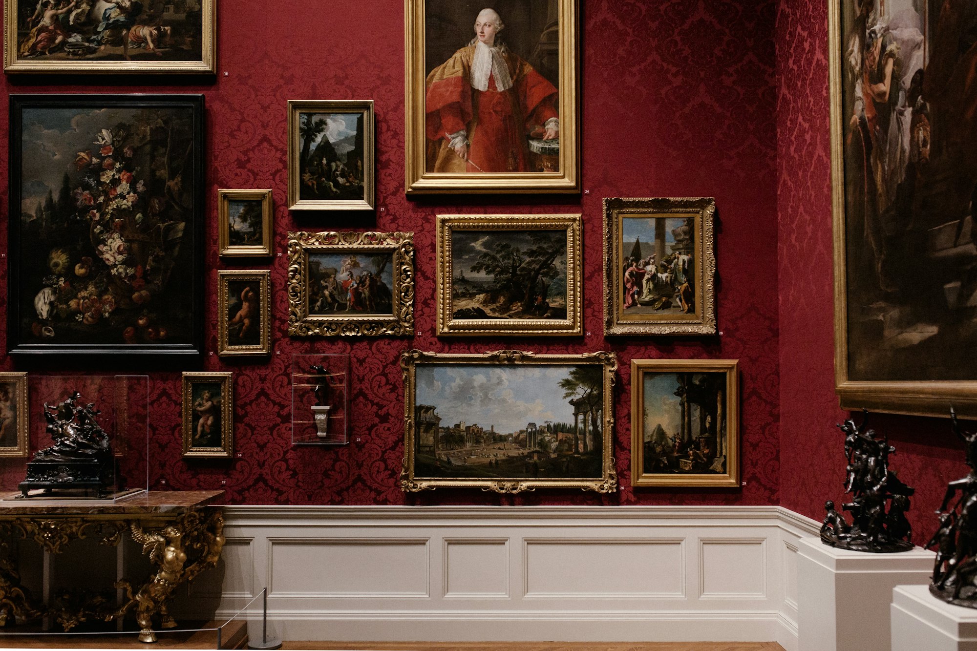 A private salon hung with gilt-framed paintings