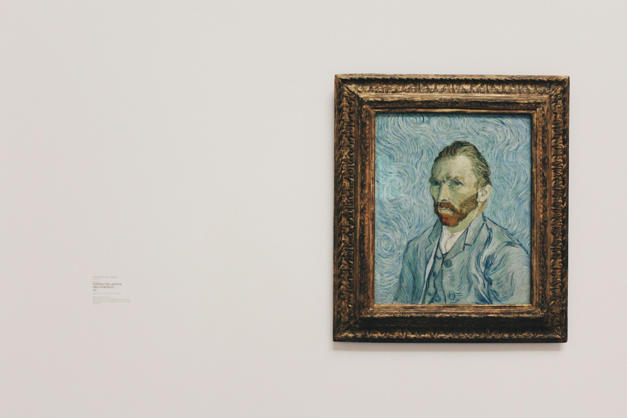 A single framed painting on a pale gallery wall