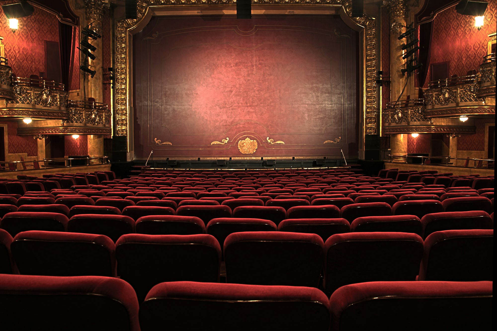 The red velvet auditorium of a Paris opera house, empty before a private evening