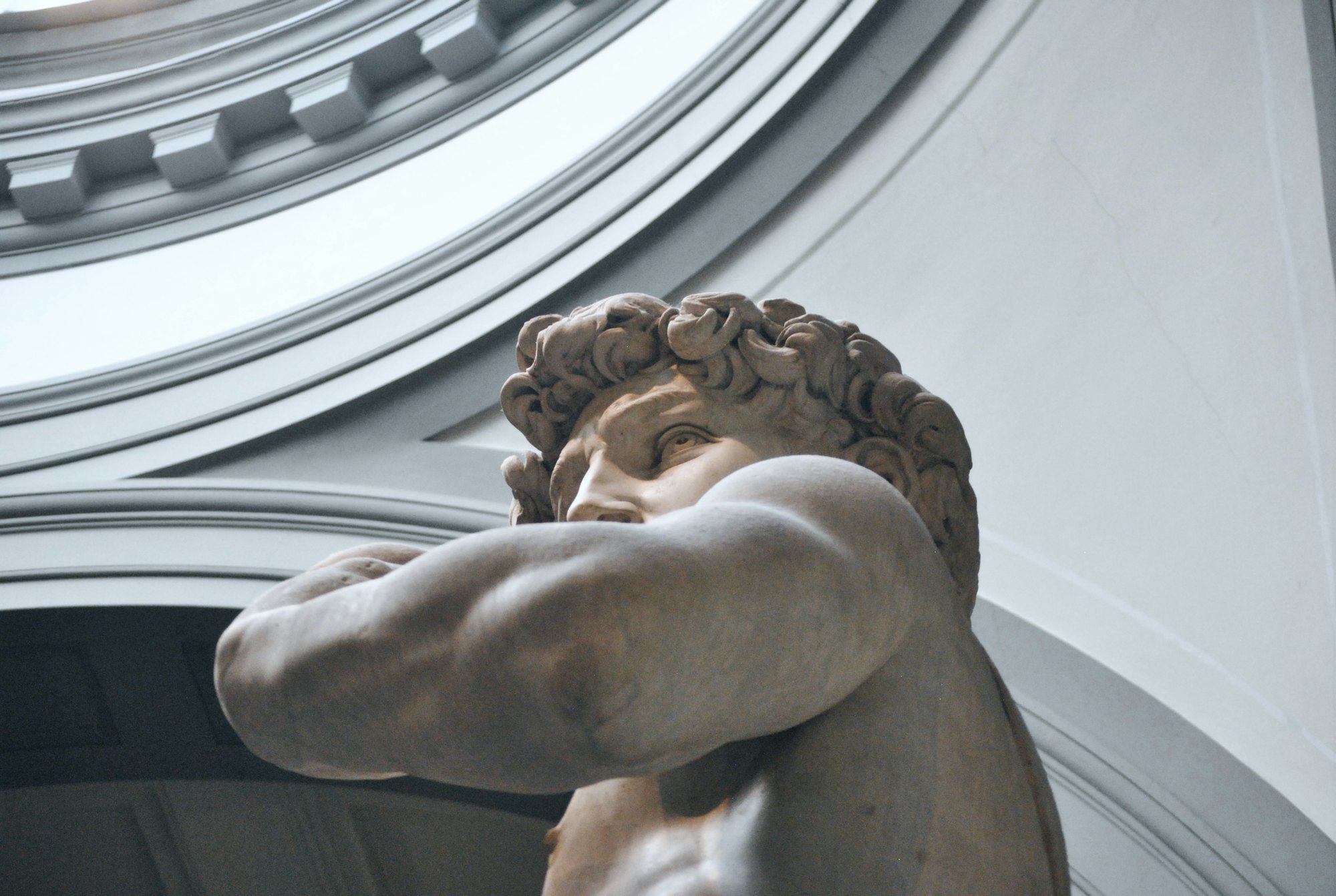 A classical marble sculpture beneath a domed ceiling
